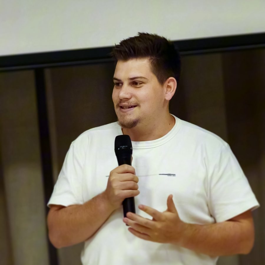 Participante apresentando ao microfone no palco